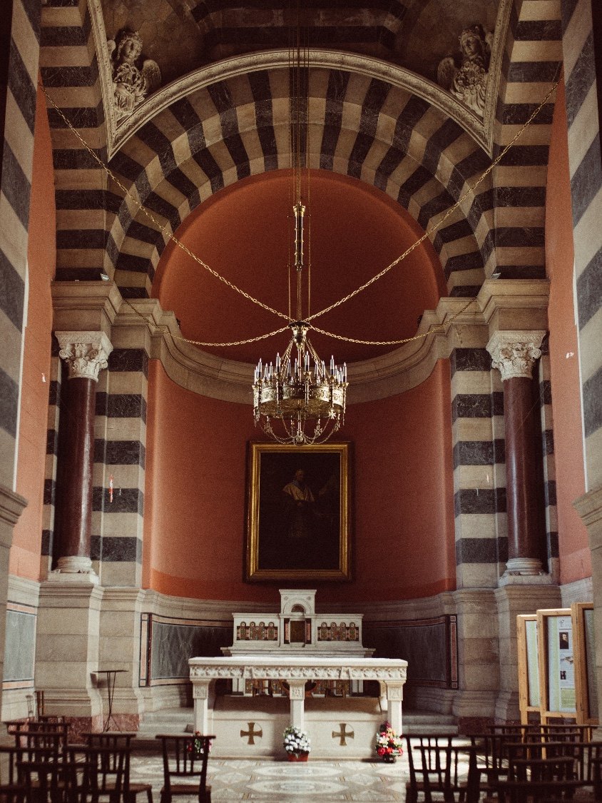 A chapel interior with striped marble arches