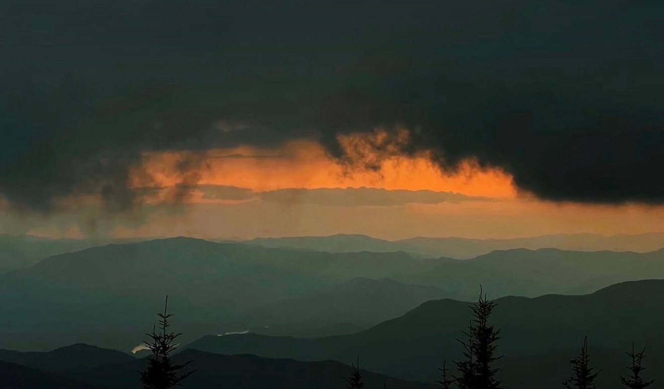 Storm clouds over mountain ridges at sunset
